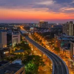 Aerial view of Nagpur news skyline at dusk with elevated metro rail tracks, modern buildings and orange-lit streets, India, realistic cityscape photography, 1200x800px landscape