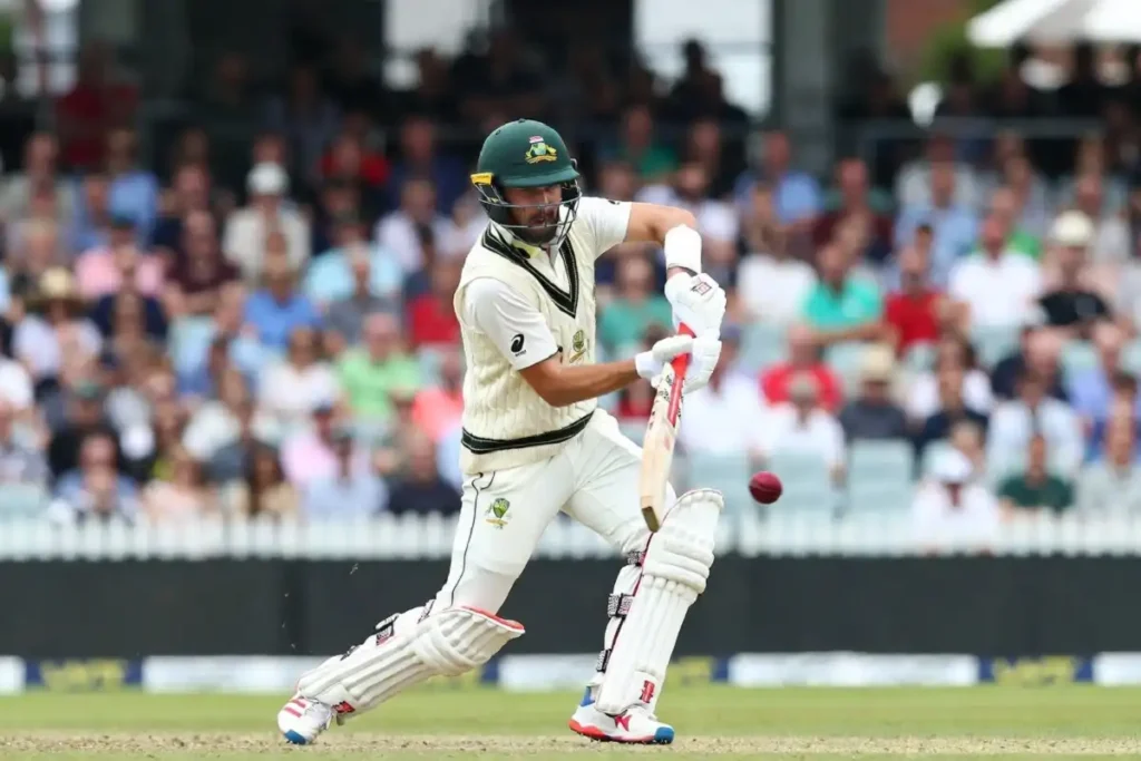 Cricket player in white Test jersey playing a cover drive on a green outfield