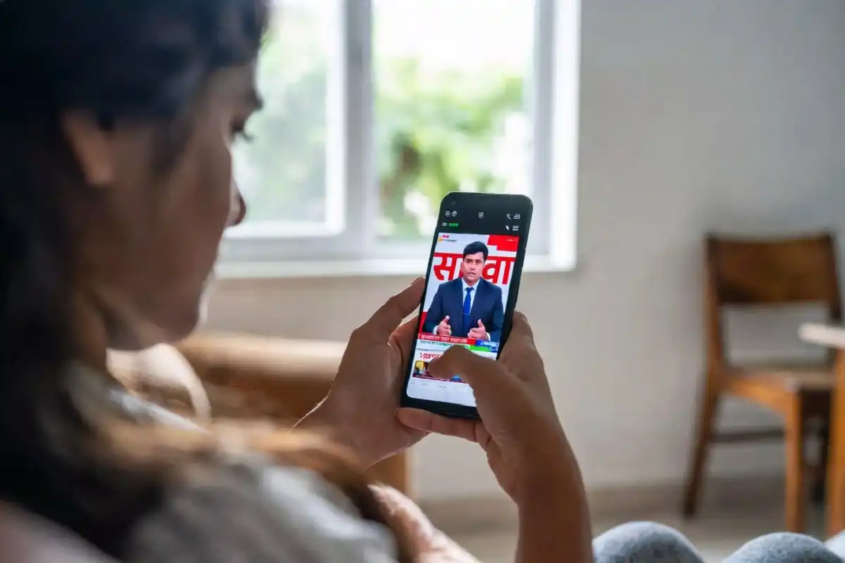 Person watching TV9 Marathi live news on a smartphone